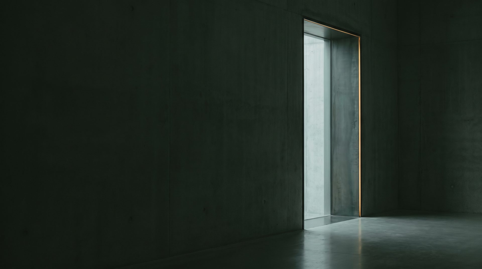 A narrow doorway in a dark concrete wall opening onto daylight